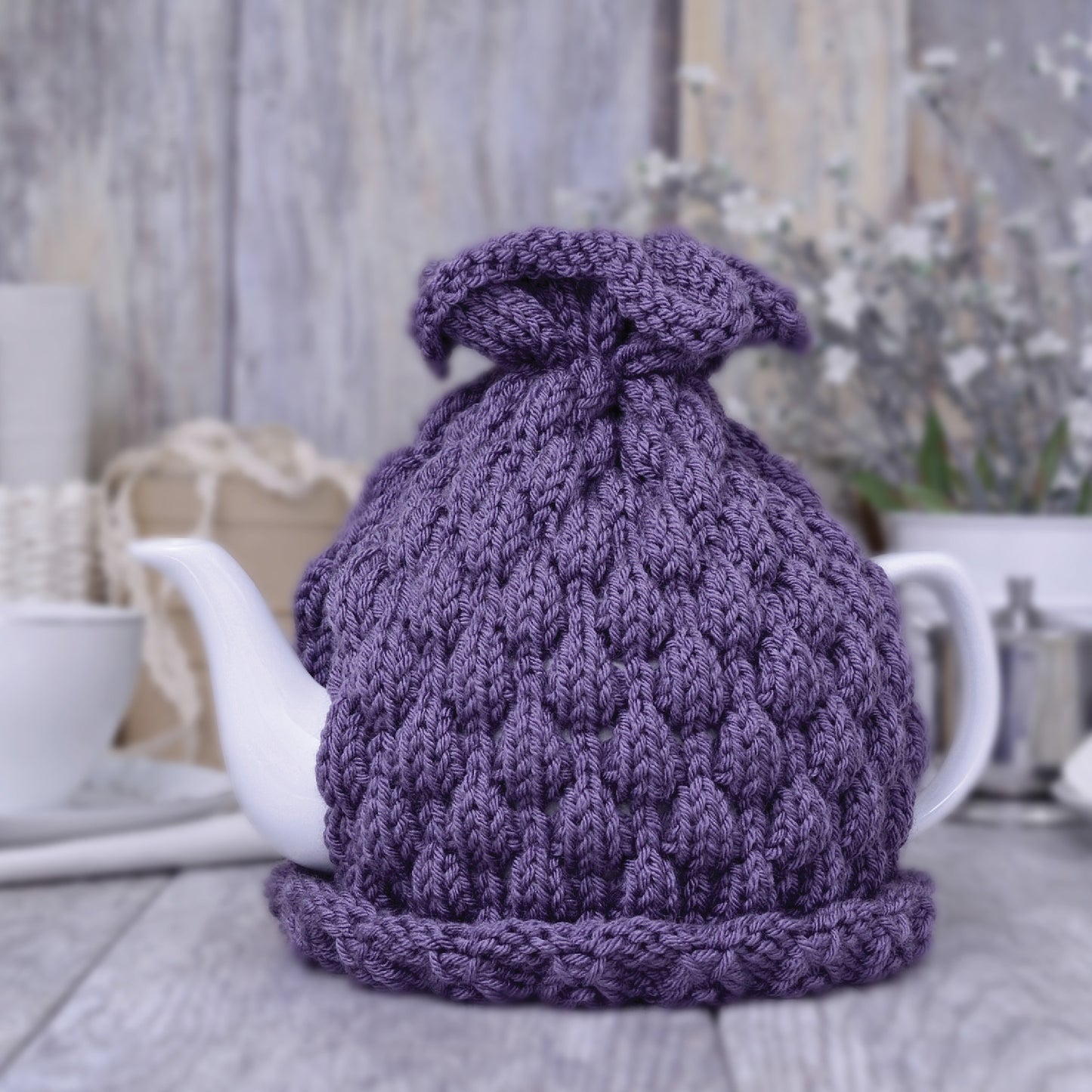 Purple knitted teapot cozy