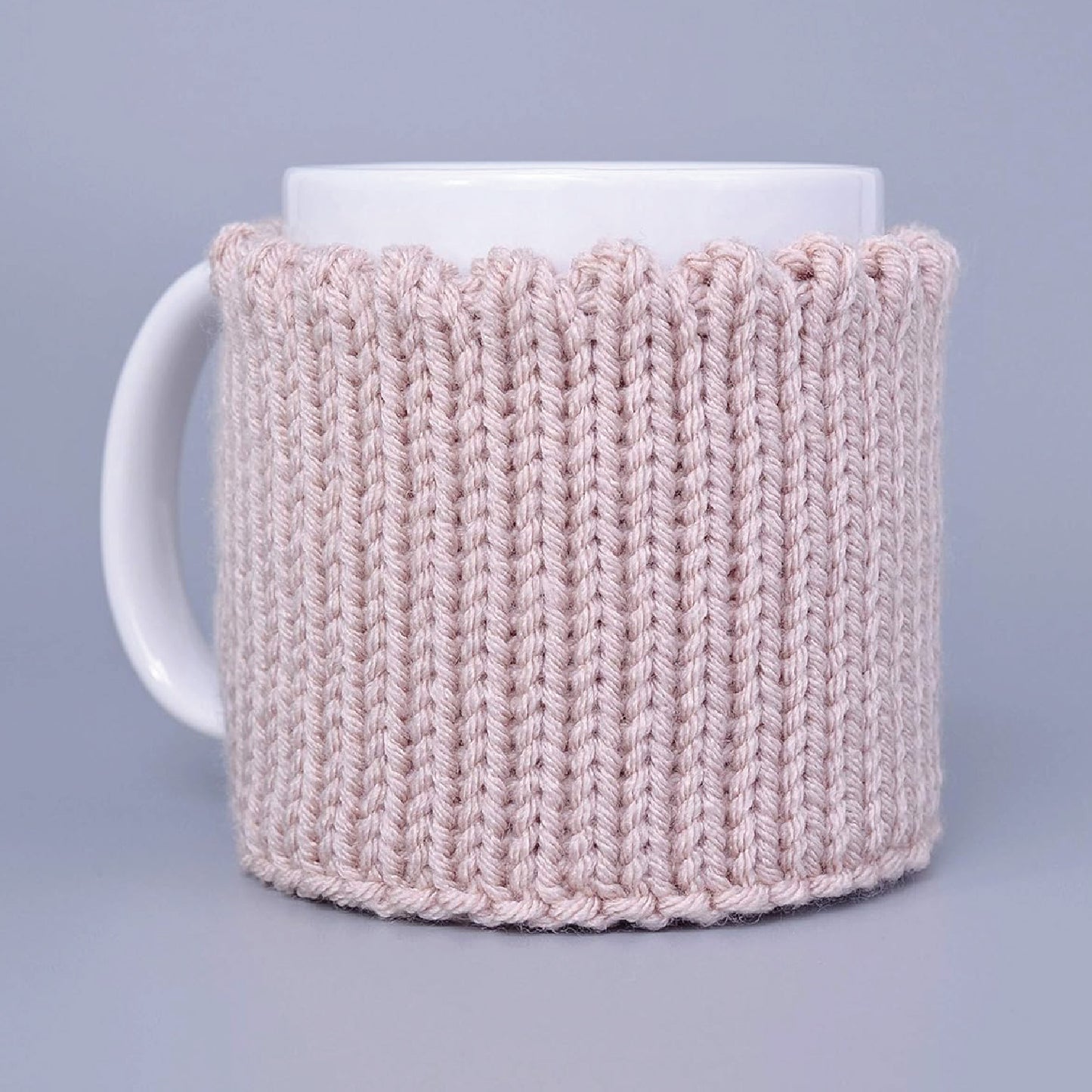 Light pink knitted mug cozy