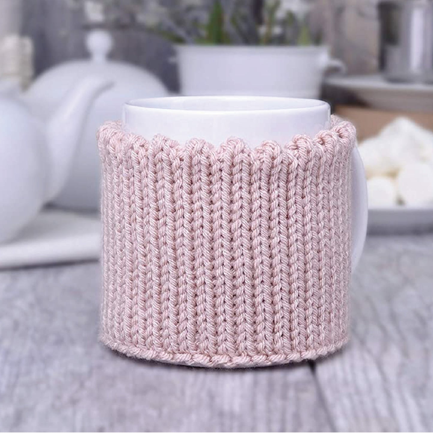 Light pink knitted mug cozy