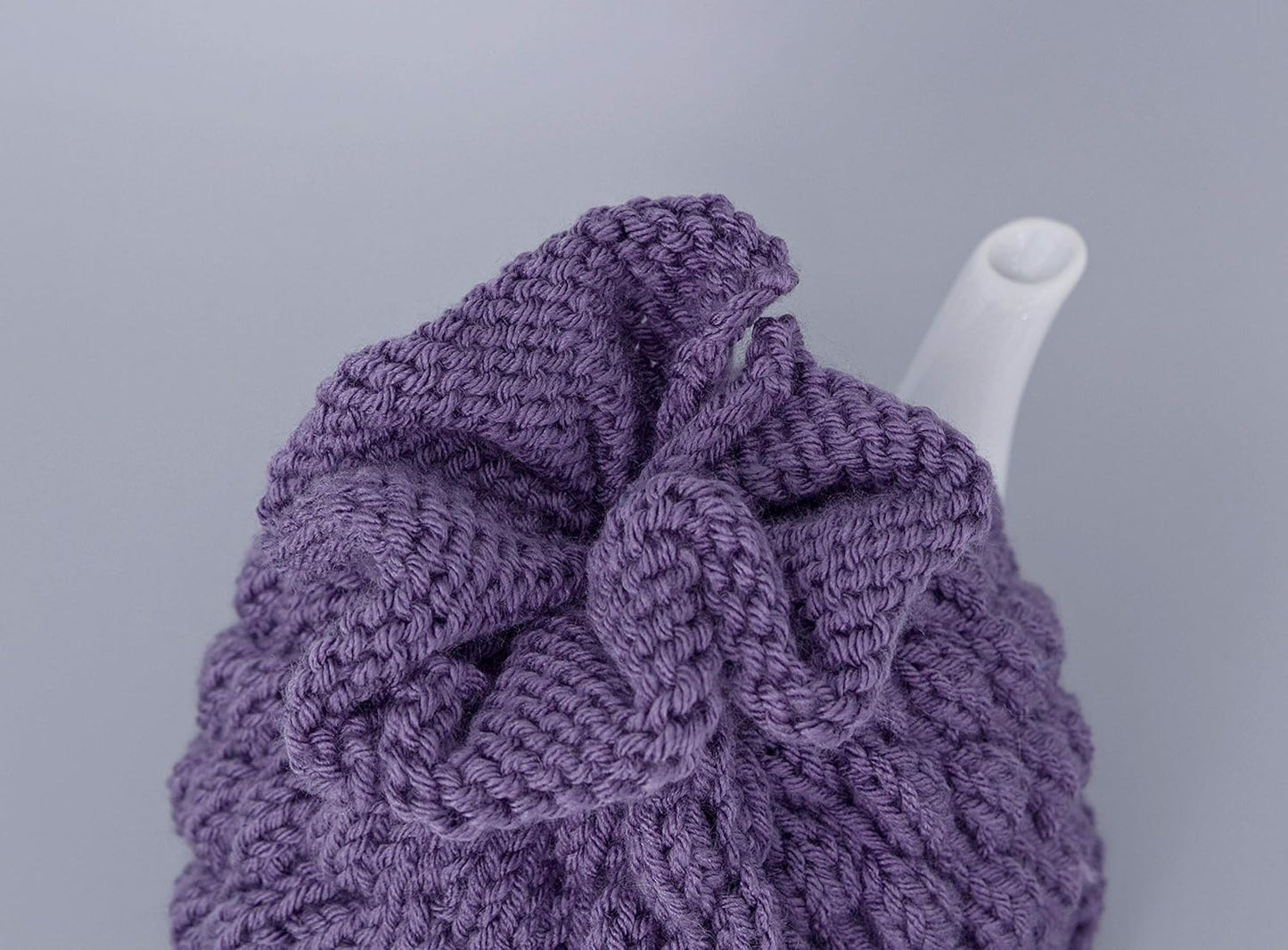 Purple knitted teapot cozy