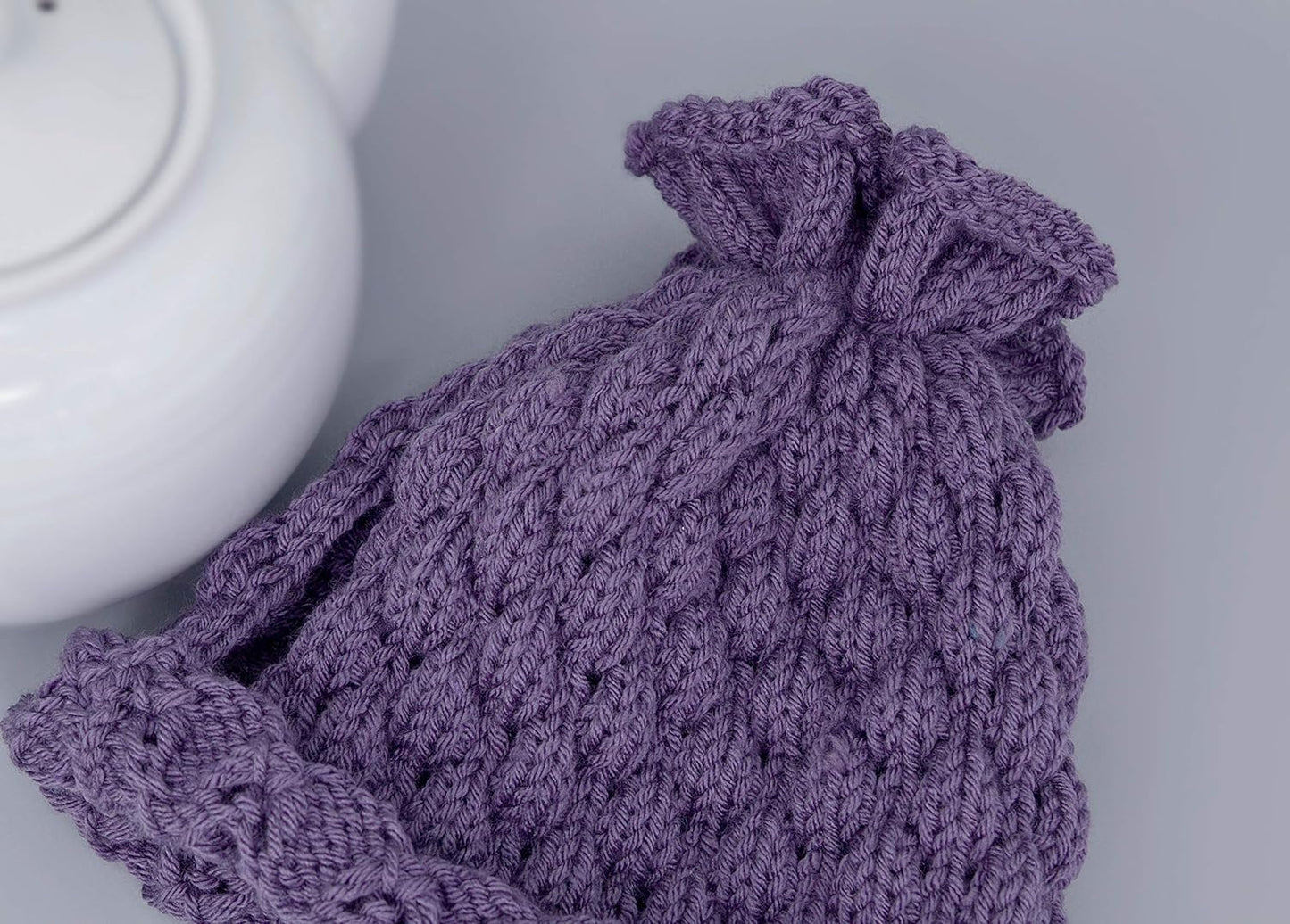 Purple knitted teapot cozy