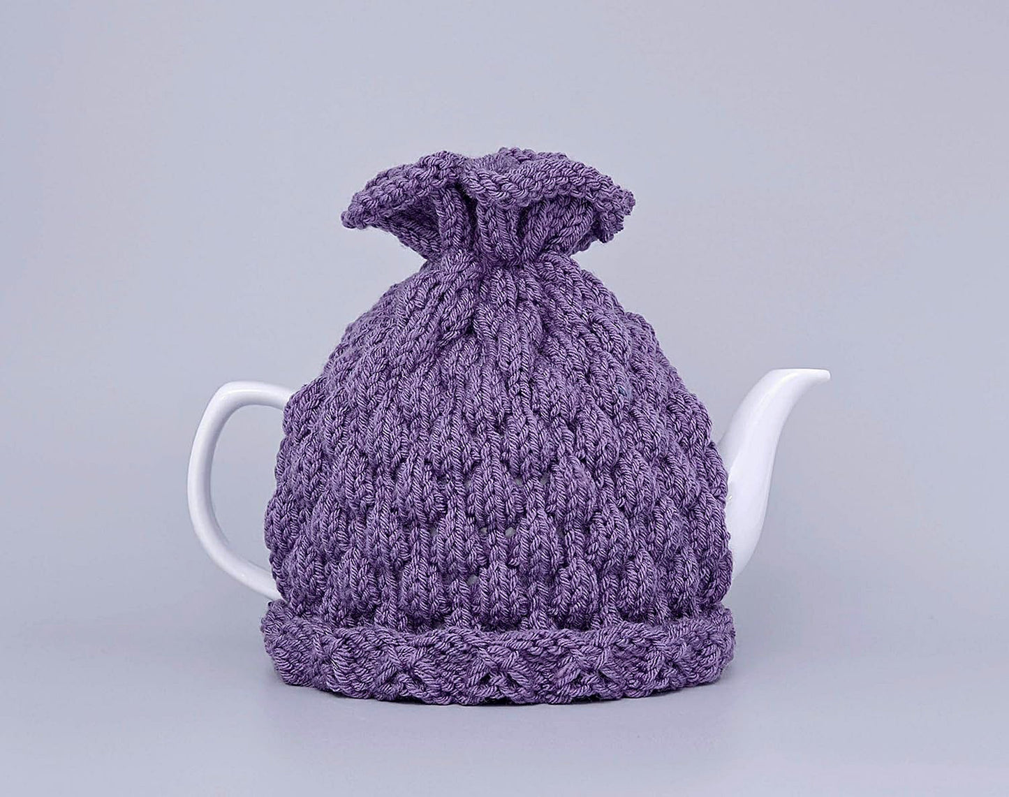 Purple knitted teapot cozy