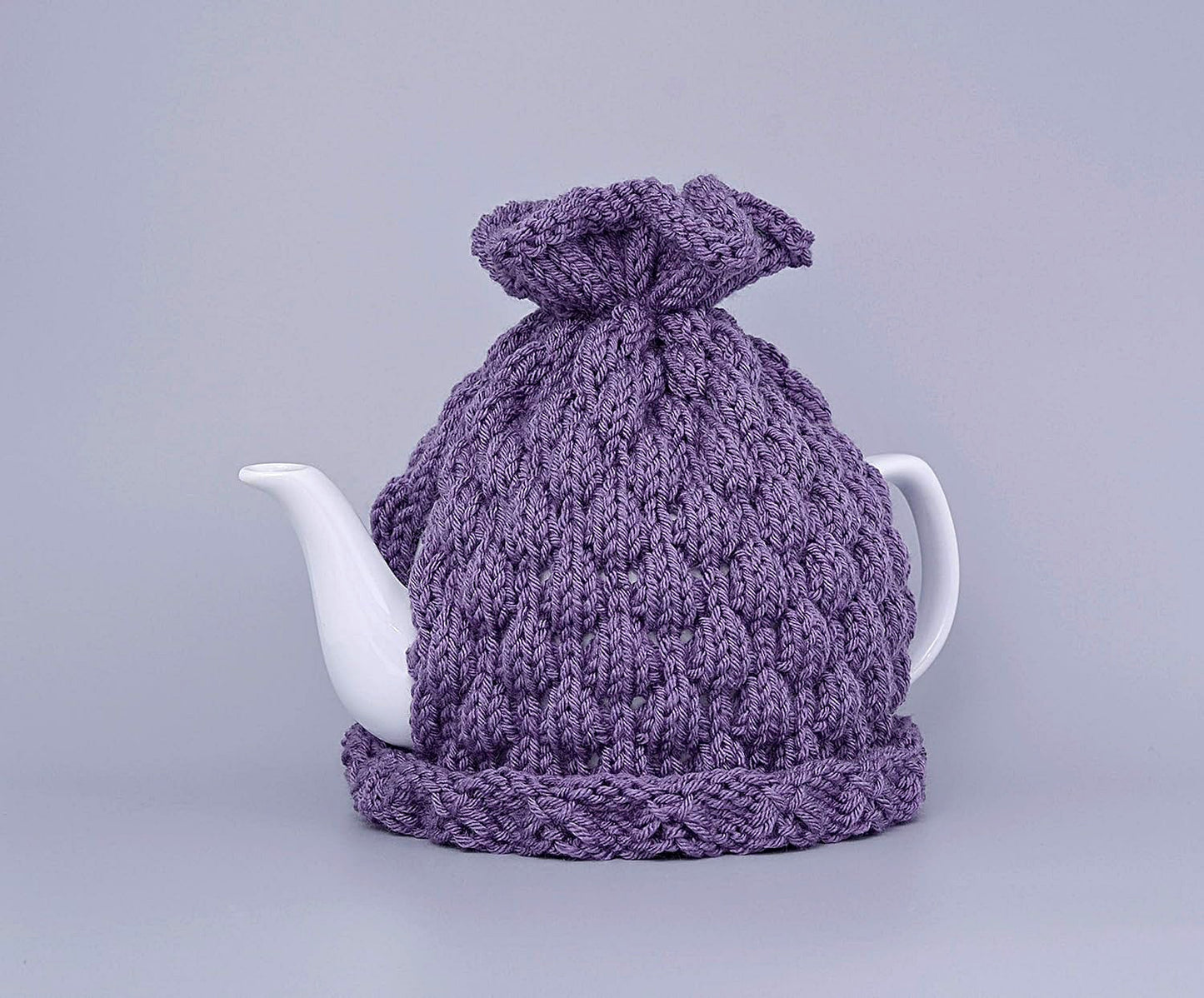 Purple knitted teapot cozy